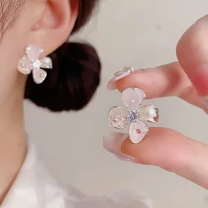 Toma de detalle que muestra el delicado diseño de pendiente de pétalo de perla y cristal.