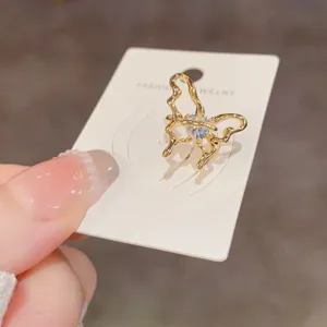 Pendiente de oreja mariposa calado dorado con cristal de corazón, elegante clip sin perforación.