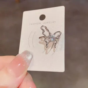 Ear cuff de mariposa hueca de metal plateado con circonita brillante, diseño único.