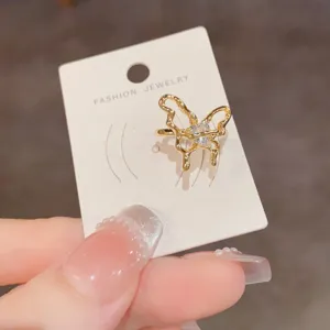 Pendiente de oreja de mariposa hueca de metal dorado simple, joyería de diseño elegante.