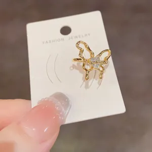 Primer plano detallado de un elegante anillo de mariposa de metal dorado con cristal.