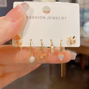 Detailed view of sweet butterfly pearl hoop earrings set, trendy metal fashion jewelry design.