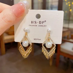 Detail van parel ruit kwast oorbellen, elegante gouden hangende oorbellen voor dames.