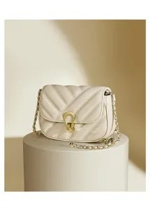 Detailed view of the elegant beige quilted crossbody bag with stylish gold chain and metal clasp.