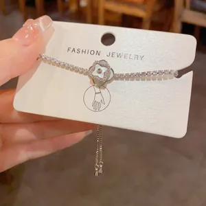 Exquisite silver tennis bracelet featuring a rotating mother-of-pearl four-leaf clover pendant.