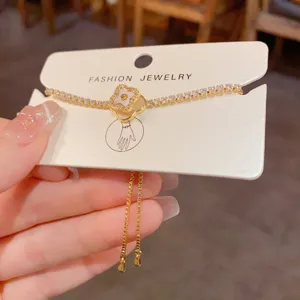 Gold-plated four-leaf clover shell charm tennis bracelet with adjustable pull closure detail.
