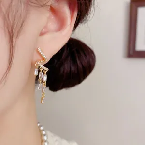 Vue détail de boucles d'oreilles gland torsion zircon exquise, bijoux étincelants argentés.