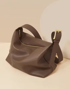 Soft brown leather slouchy shoulder bag close-up showcasing fine texture and golden metal hardware details.