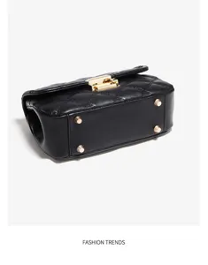 Sac bandoulière matelassé noir en cuir avec quincaillerie dorée et pieds de base en détail