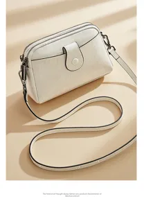 Elegant white leather crossbody bag for women, featuring dual zippers and simple stylish design.