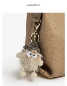 Cute plush doll keychain bag charm hanging on a stylish leather bucket bag for women.