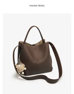 Brown leather bucket bag with cute furry monster pendant and adjustable strap detail