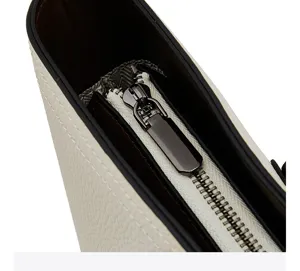 Close-up detail shot of white leather tote bag zipper and texture, premium commuter handbag.