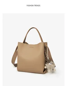 Elegant PU leather bucket bag with top handle, adjustable strap and cute furry charm for daily use.