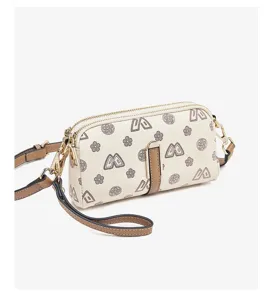 Women small crossbody phone bag detail, stylish monogram print leather shoulder handbag.