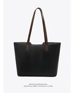 Close-up of black leather tote bag handle and textured fabric detail, stylish and durable.