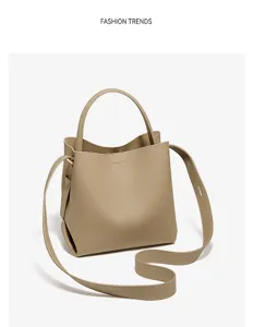 Stylish leather bucket bag with top handle and shoulder strap in elegant khaki color.