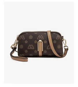 Close-up detail of the brown monogram crossbody phone bag with metal clasp and leather strap.