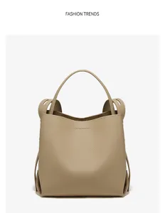 Minimalist beige leather bucket bag with top handle and stylish side structure for women.