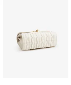 Detailed view of the white quilted leather handbag featuring elegant chevron pattern and gold lock.