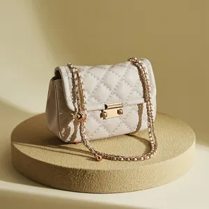 Sac bandoulière matelassé beige en cuir avec chaîne pour femme élégant et minimaliste chic