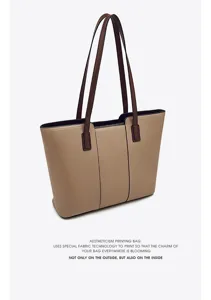Close-up detail of the two-tone leather tote bag, showing premium stitching and textured finish.