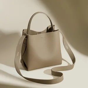Elegant leather bucket bag with top handle and crossbody strap for women daily chic style.