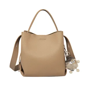 Elegant taupe leather bucket bag with cute furry pendant, stylish single shoulder crossbody.