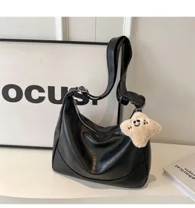 Classic black PU leather underarm shoulder bag with wide strap and cute plush charm for daily.