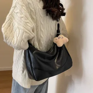 Black leather underarm bag for women, retro wide strap shoulder bag with cute plush charm.