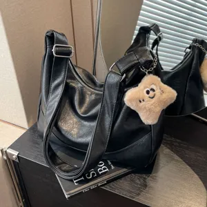 Black vintage underarm shoulder bag for women, wide strap hobo crossbody bag with cute plush charm.