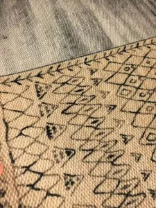 Close-up detail of modern minimalist printed sisal-effect rug with geometric pattern.
