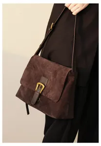 Brown suede shoulder bag detail, vintage metal buckle, premium leather crossbody design.