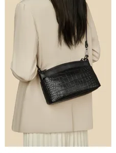 Black crocodile embossed leather shoulder bag detail, stylish commute handbag texture closeup.