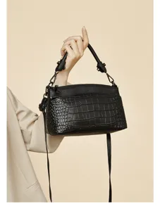 Black genuine leather crocodile embossed women crossbody bag detail view with metallic zippers.