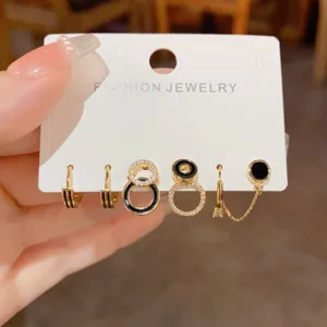 Schickes mehrteiliges Ohrring-Set im minimalistischen Stil mit schwarzen runden Details.