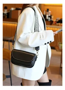 Detail view of a black vintage crossbody small square bag with a wide patterned strap.