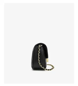 Side detail view of the elegant black quilted mini cross-body bag with luxury gold chain strap.