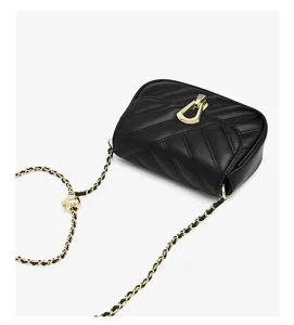 Black quilted crossbody bag with gold hardware and leather woven chain strap. Stylish mini bag.