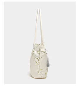 Detailed side view of the elegant Chinese style tote bag featuring bamboo print and tassel.