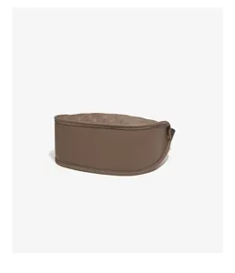 Brown leather bag bottom detail close-up, premium cowhide texture and neat stitching.