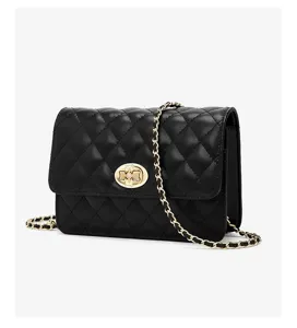 Close-up detail of the black quilted leather shoulder bag featuring a gold chain strap.