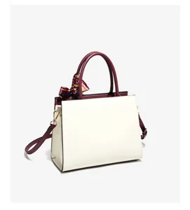 Chic colorblock tote bag with elegant scarf accessory, perfect for stylish daily commuting.