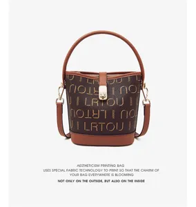 Detailed view of the brown leather bucket bag featuring unique printed patterns and gold buckle.