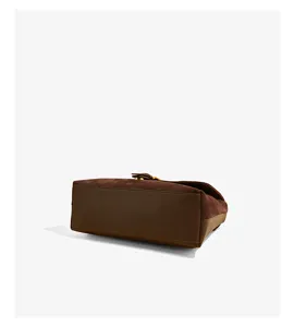 Brown suede shoulder bag detail view, premium leather texture and metal clasp hardware.