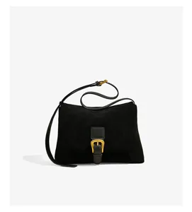 Detailed view of women's black suede shoulder bag with elegant gold metal buckle and strap.