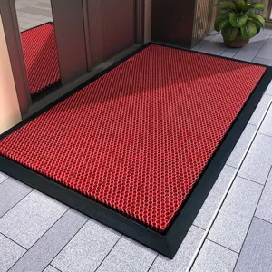 Detailed view of the red anti-slip doormat with black border, showing high elastic mesh.
