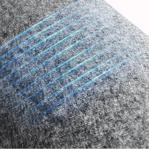 Close-up detail of grey plush carpet mat showing soft texture and blue stitching lines.