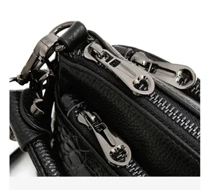 Detailed view of black genuine leather shoulder bag with multiple compartments and hardware.