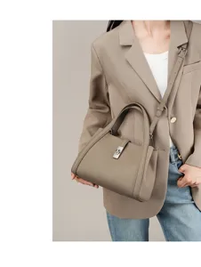 Detail view of the premium leather handbag worn with a chic blazer, showcasing elegant hardware.